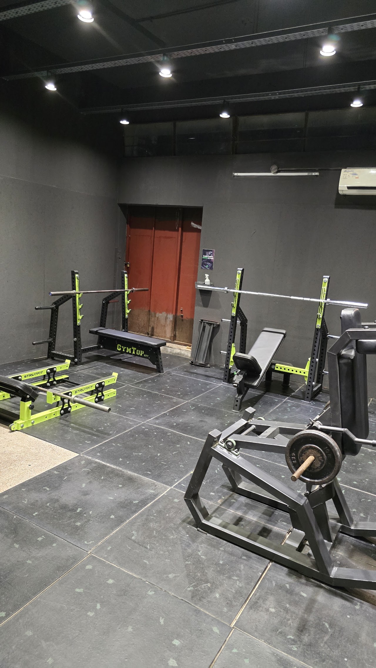 Sala de musculación de Green Club Gym con racks y bancos